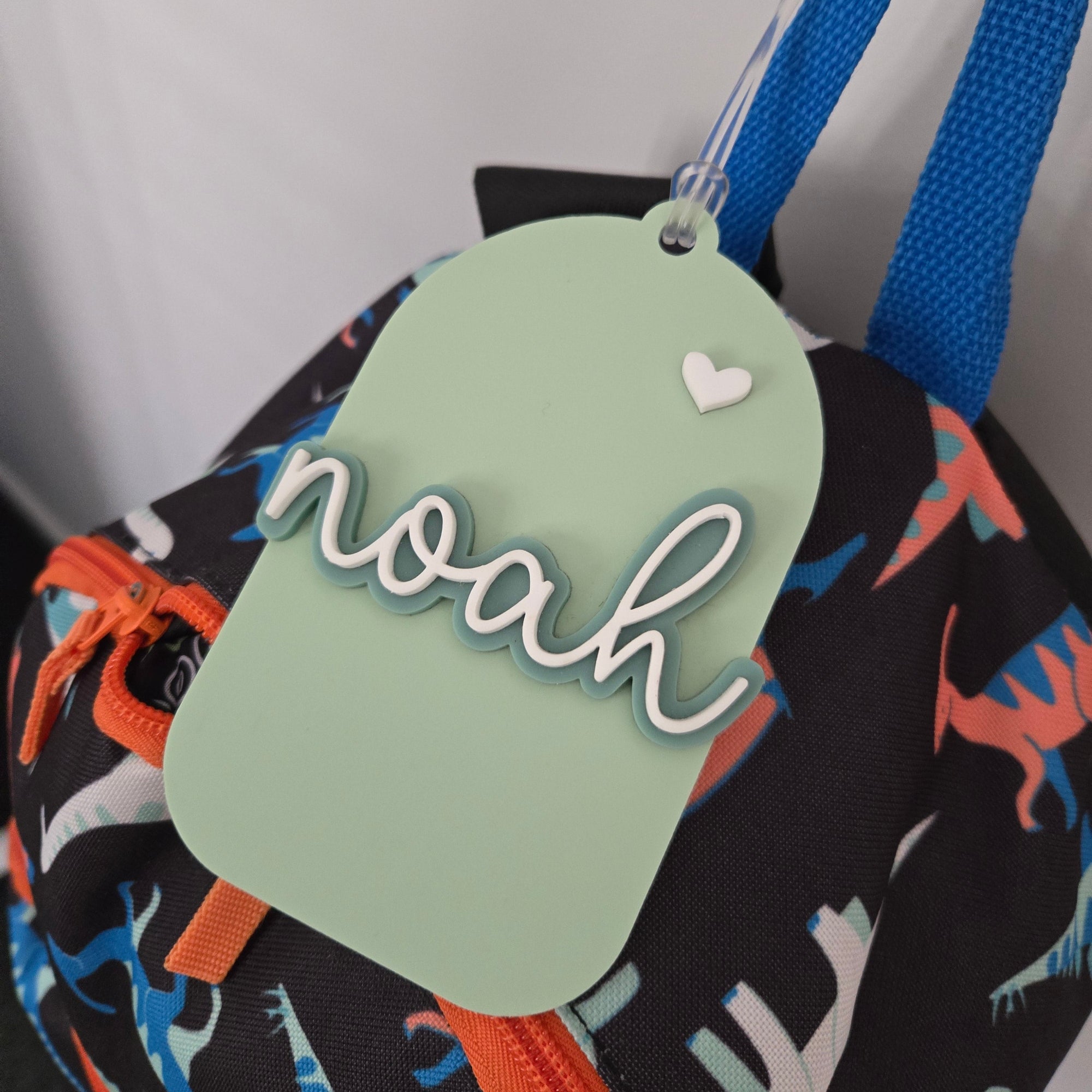 Colorful bag with a green tag featuring the name 'noah' on a white background